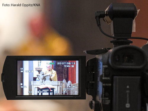 Priester im Bildschirm einer Kamera bei der Feier der Ostermesse mit Übertragung im Livestream