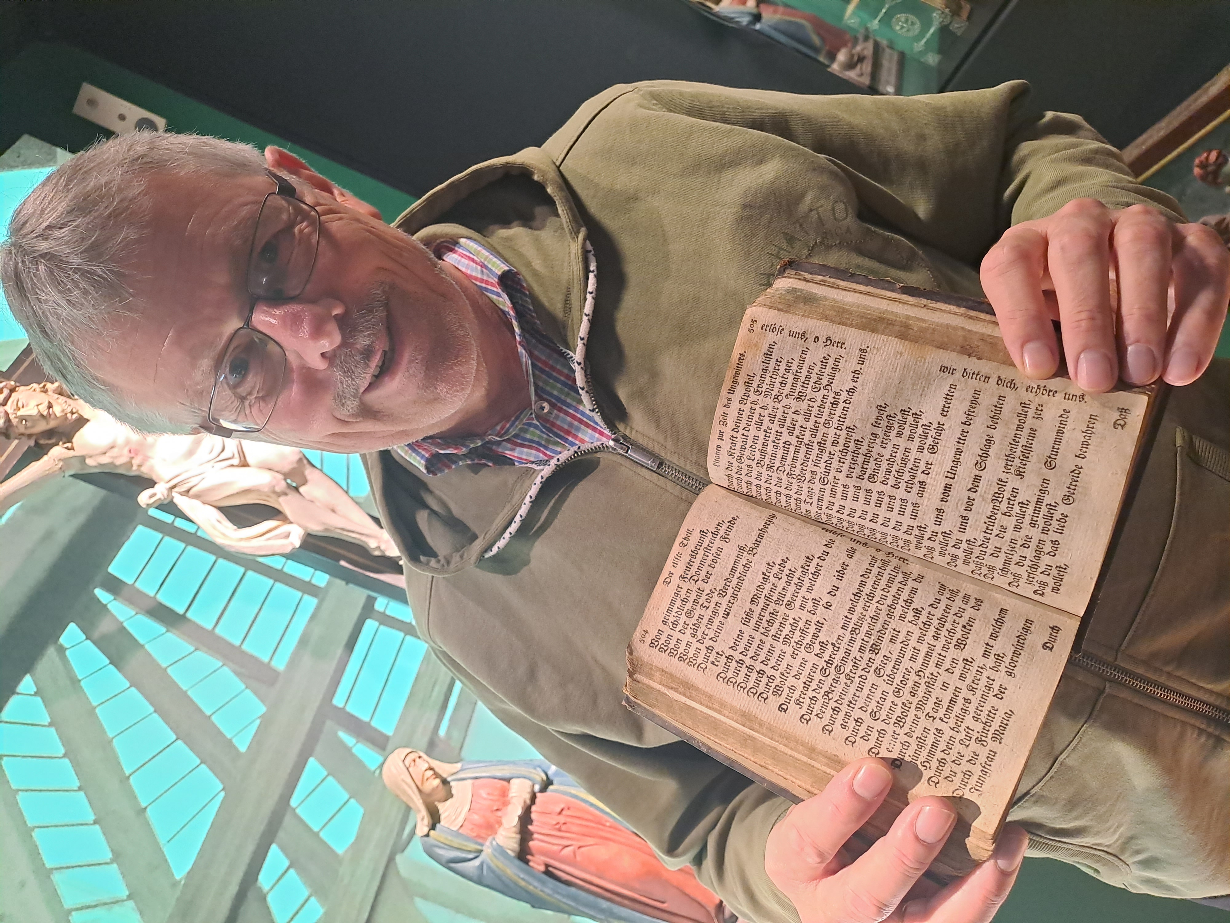 Ein Mann zzeigt ein Buch.