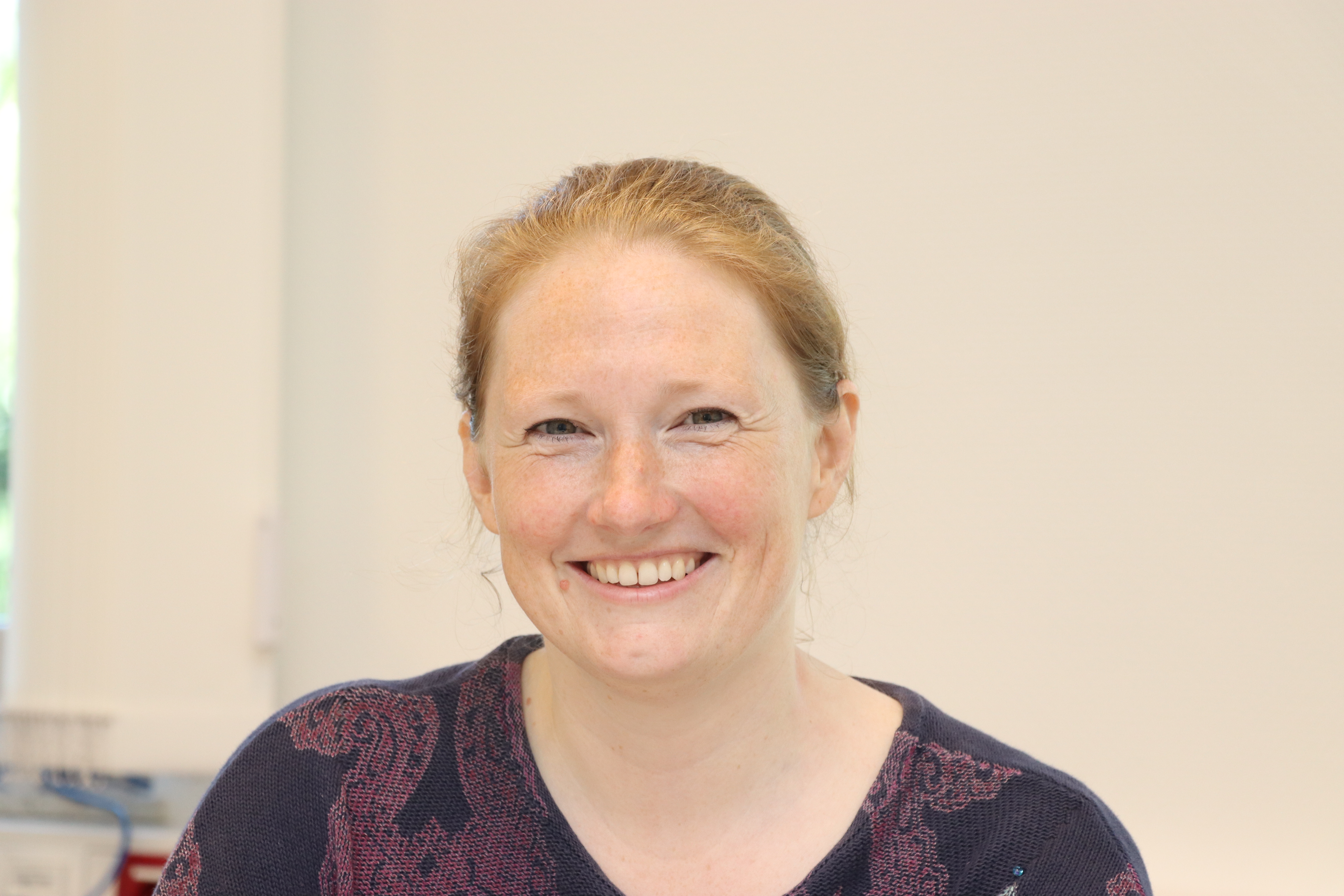 Eine junge Frau lächelt in die Kamera