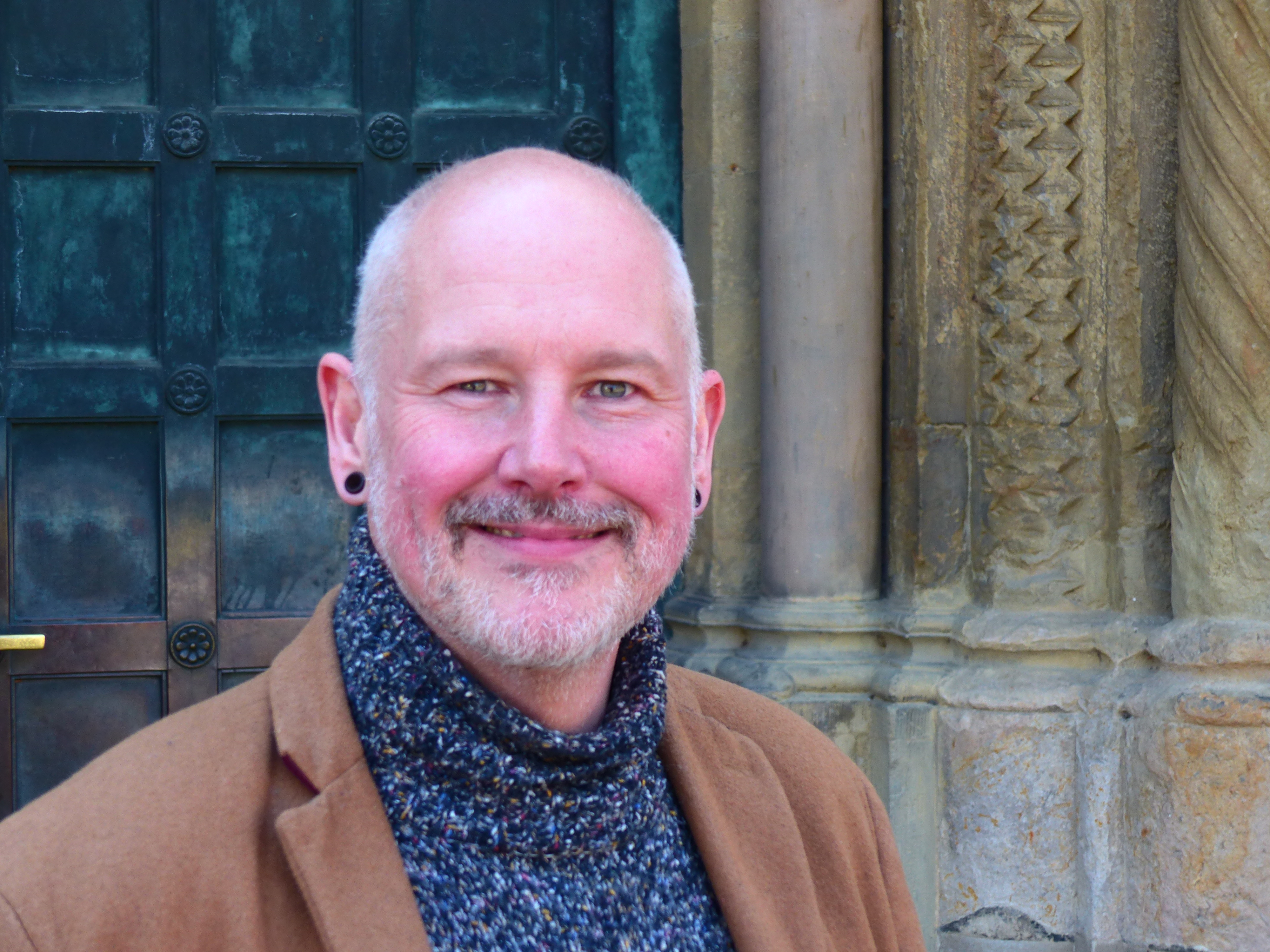 Ein Mann steht vor einer Eingangstür