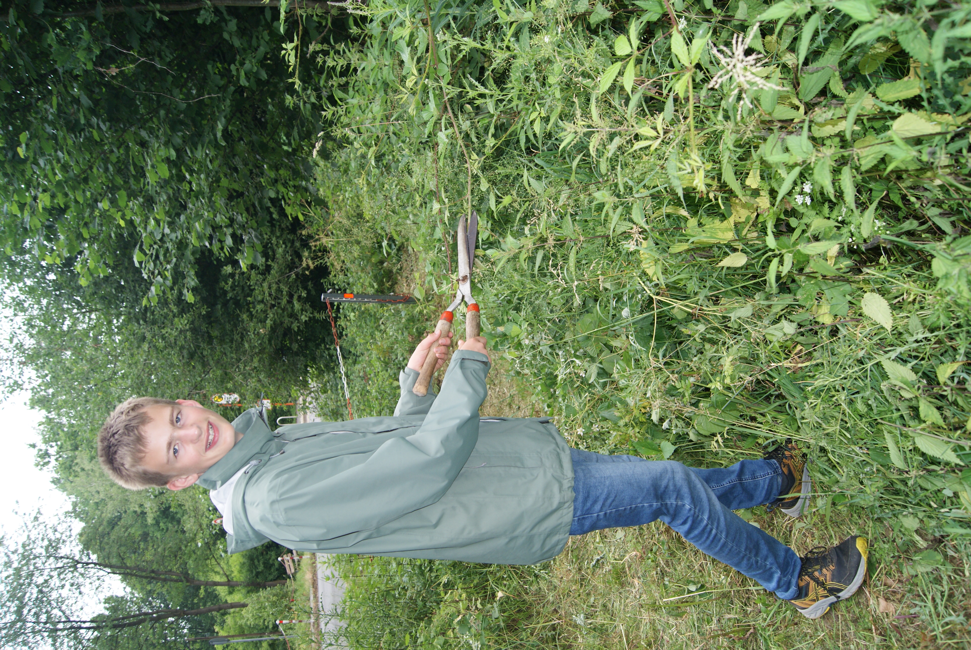 Ein junger Mann schneidet Blätter im Wald