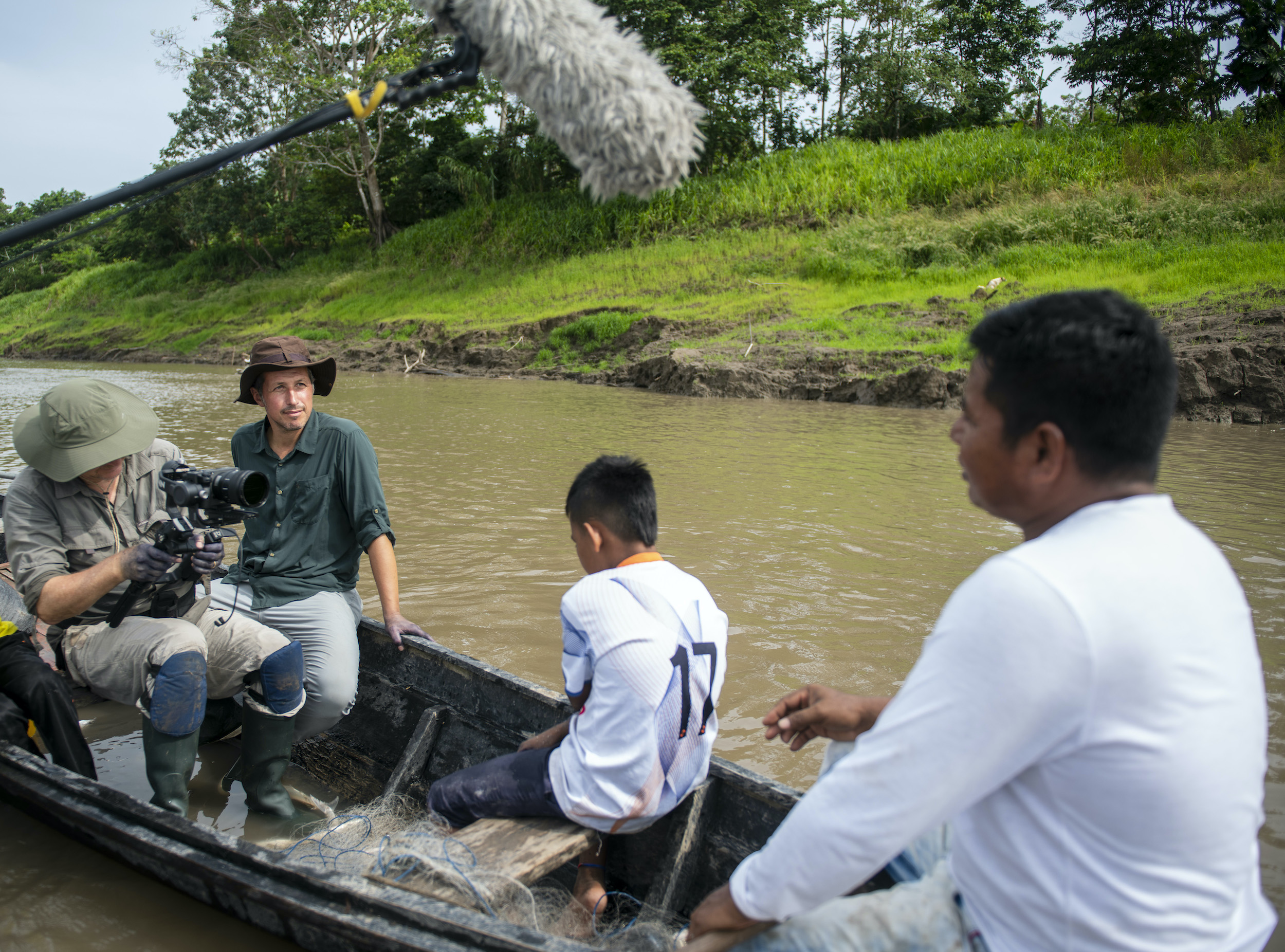 Willi Weitzel sitzt in einem Boot auf dem Amazonas