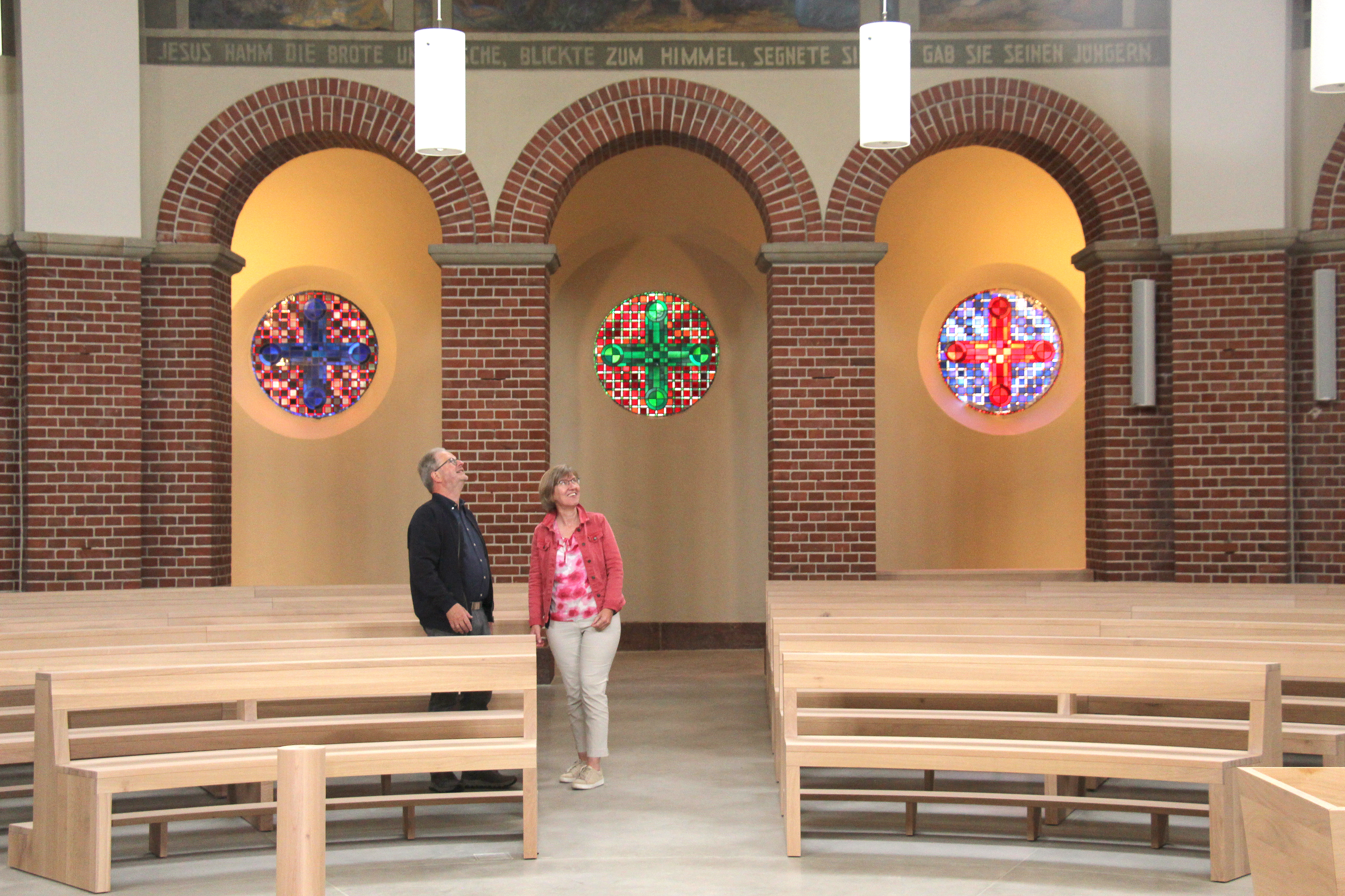 Ein Mann und eine Frau stehen in einer Kirche und schauen nach oben.