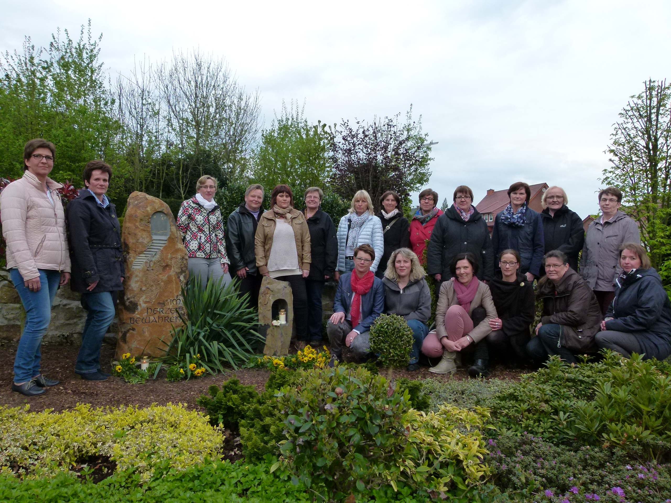 Viele Frauen bei einer Grabstätte.
