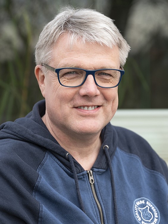 Portraitbild eines Mannes mit grauen Haaren und einer dunklen Brille