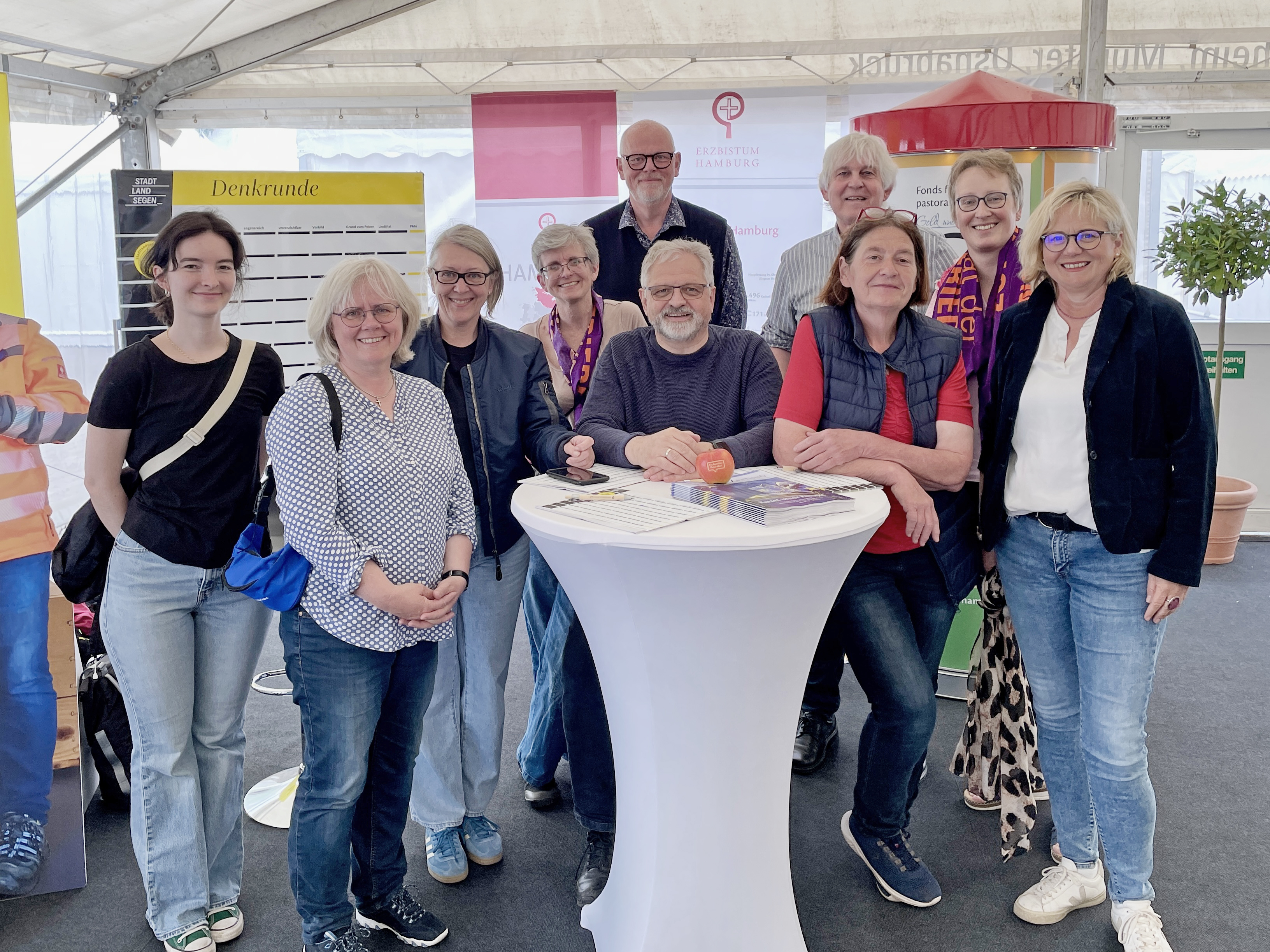 Personen stehen um einen Tisch