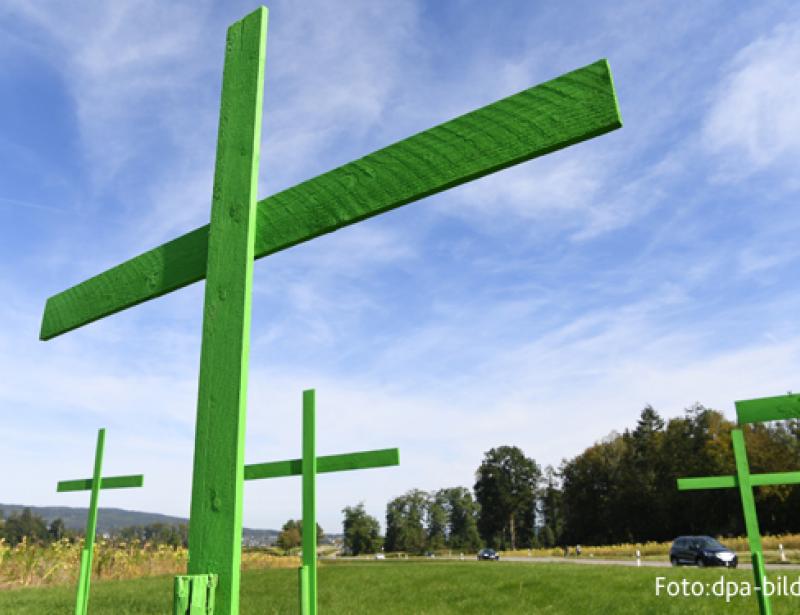 Grüne Kreuze am Wegesrand
