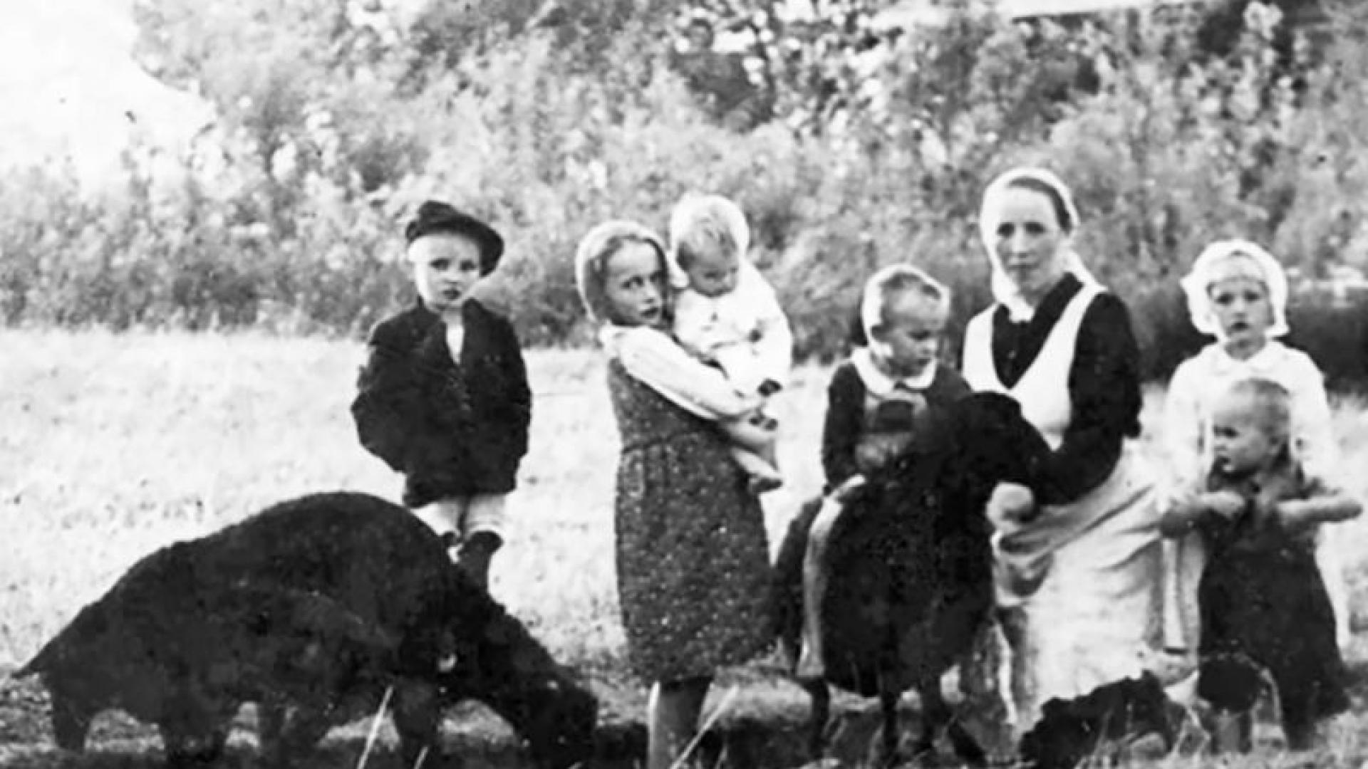 Historisches Bild einer Frau mit sechs Kindern draußen