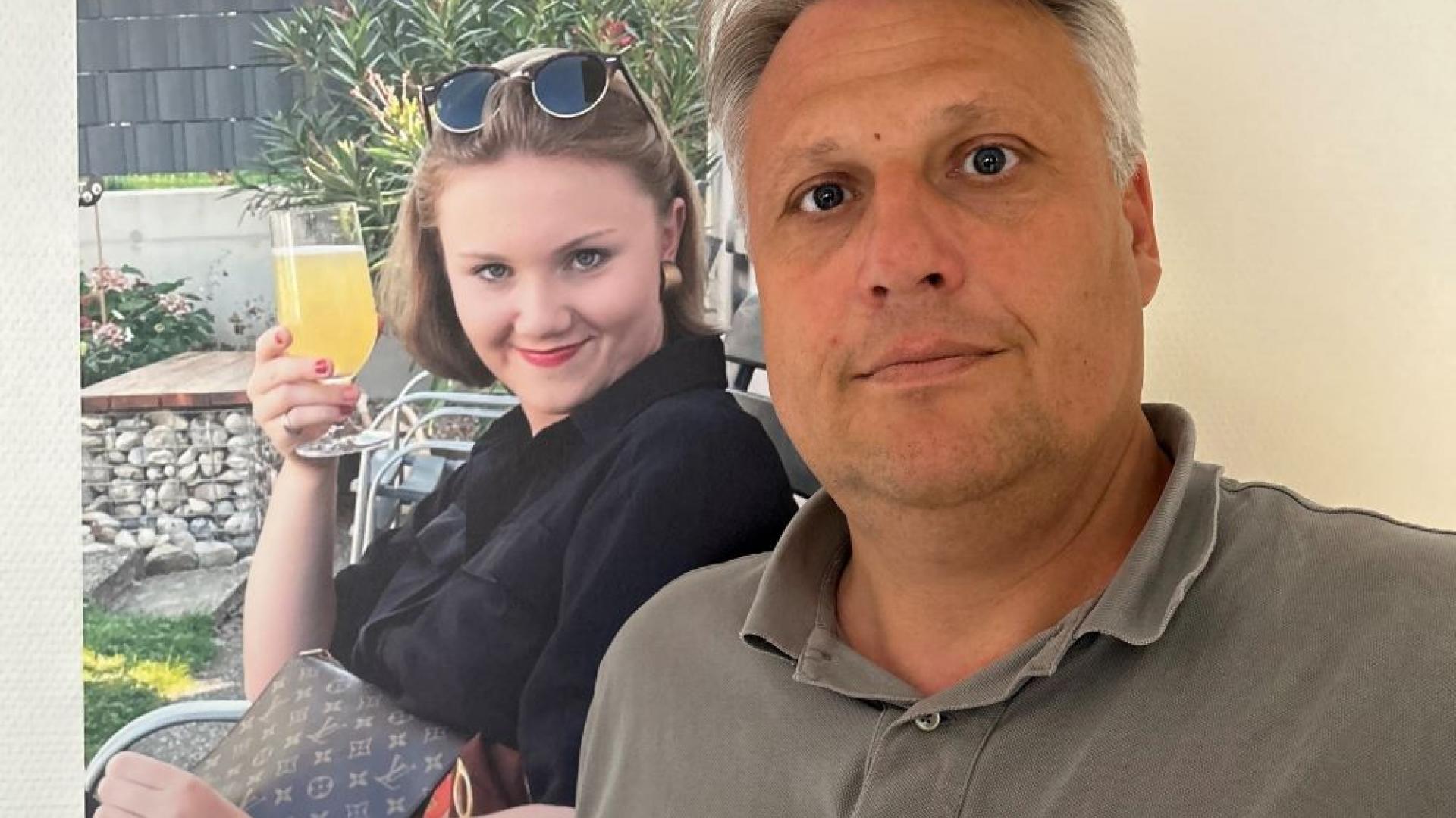 Vater steht vor einem Foto seiner Tochter