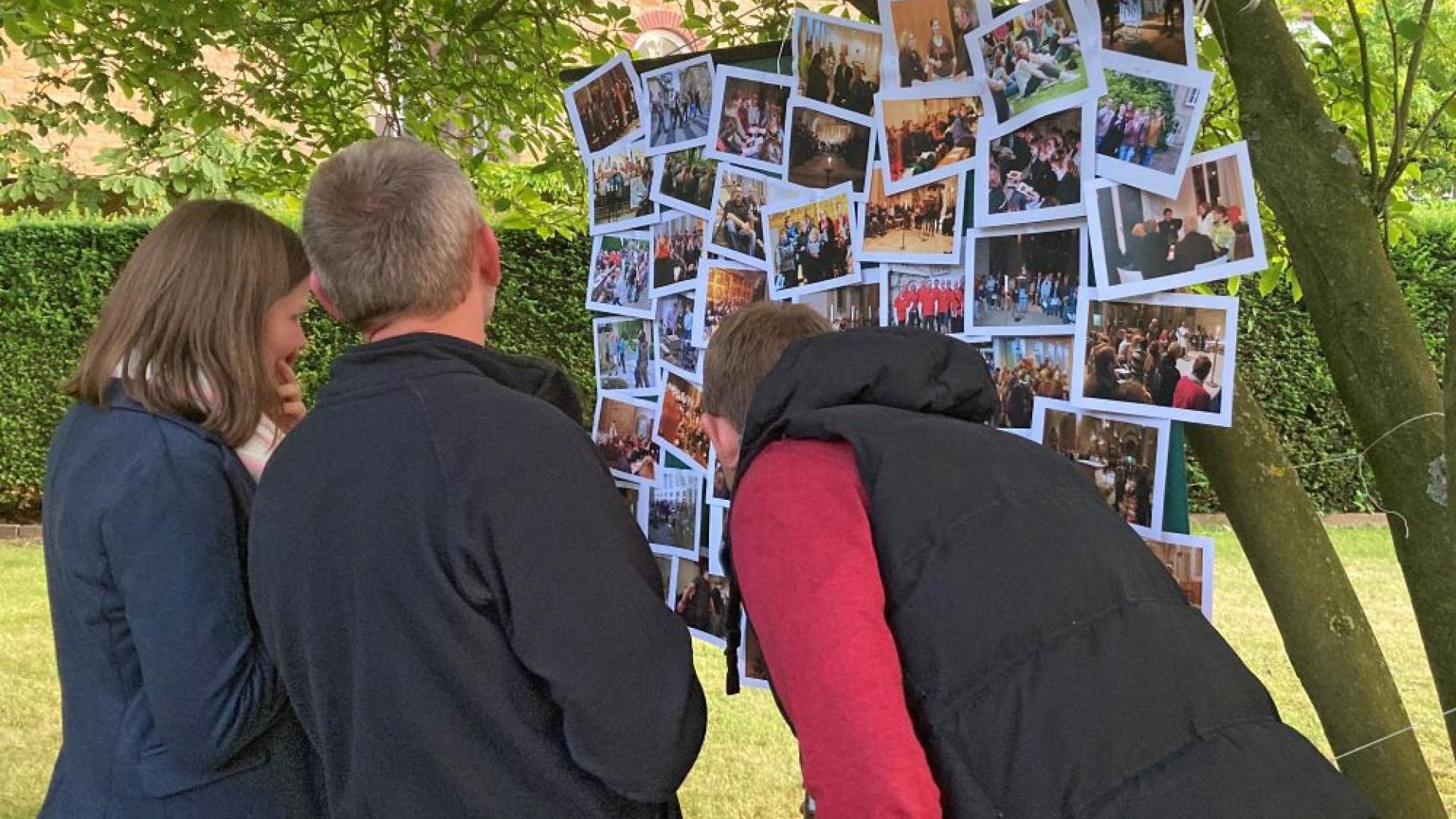 Junge Leute schauen sich Fotos an.