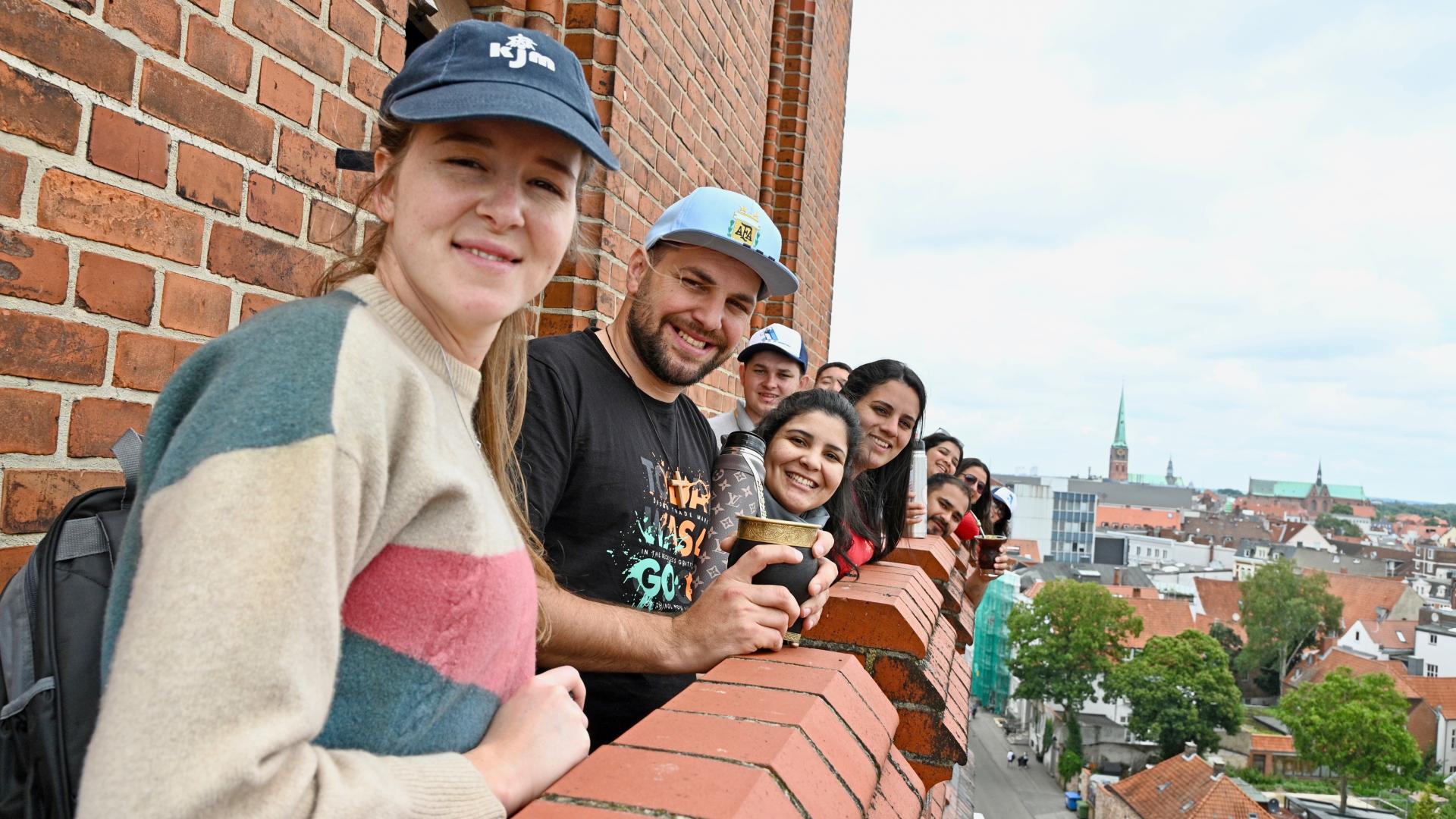 Junge Erwachsene lächeln in die Kamera.