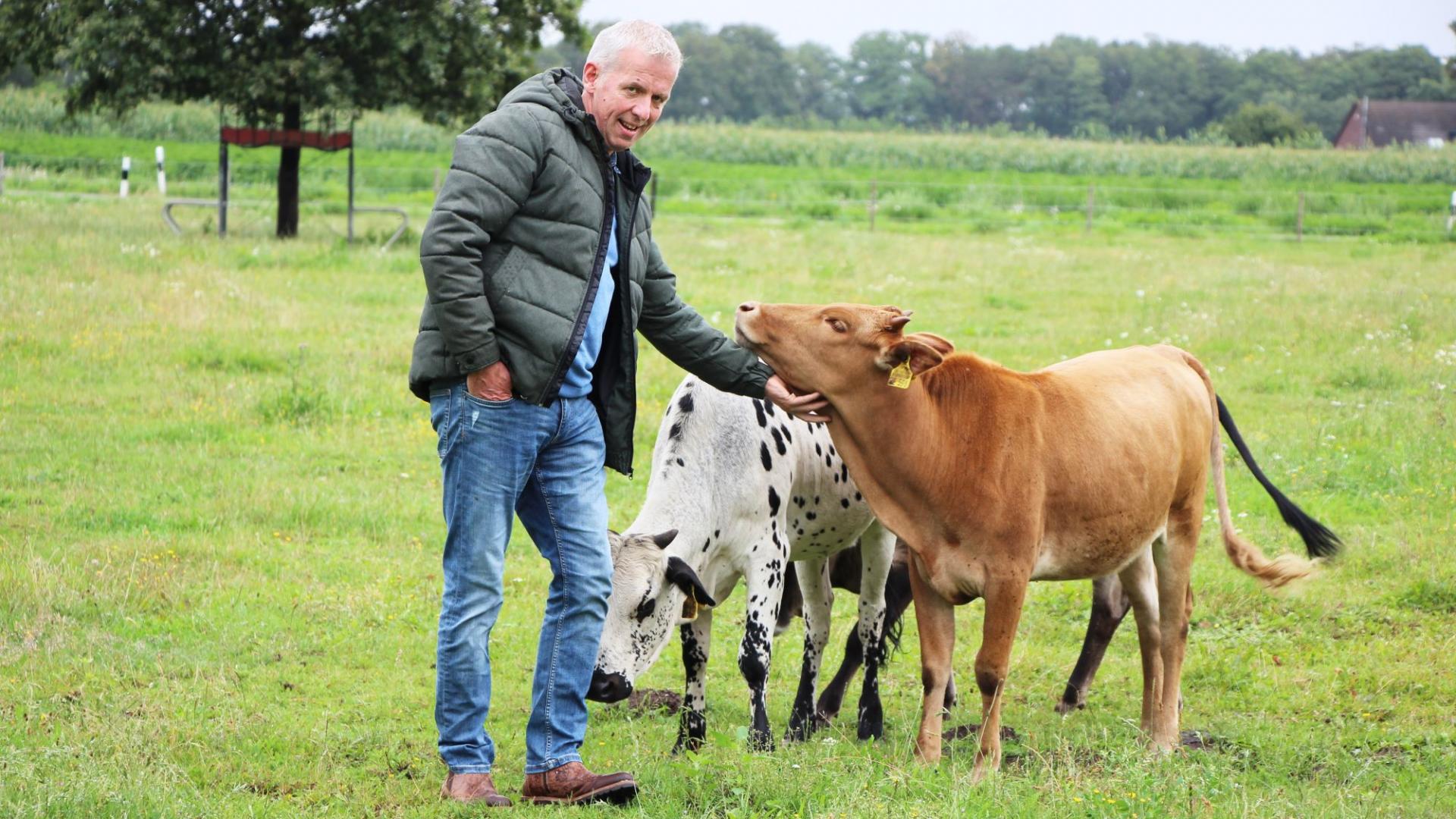 Andreas Brinker steht mit zwei Kälbern auf einer Wiese