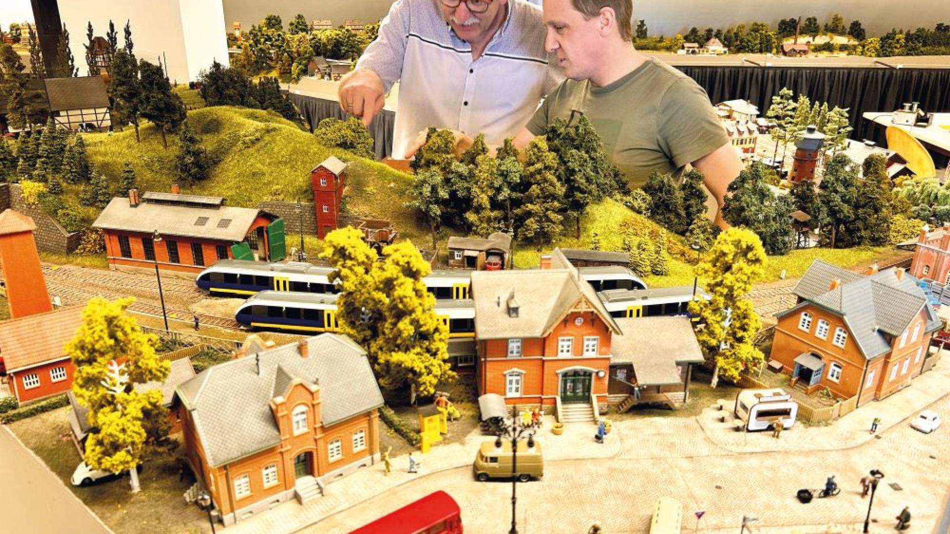 Zwei Männer fachsimpeln über eine Modelleisenbahn