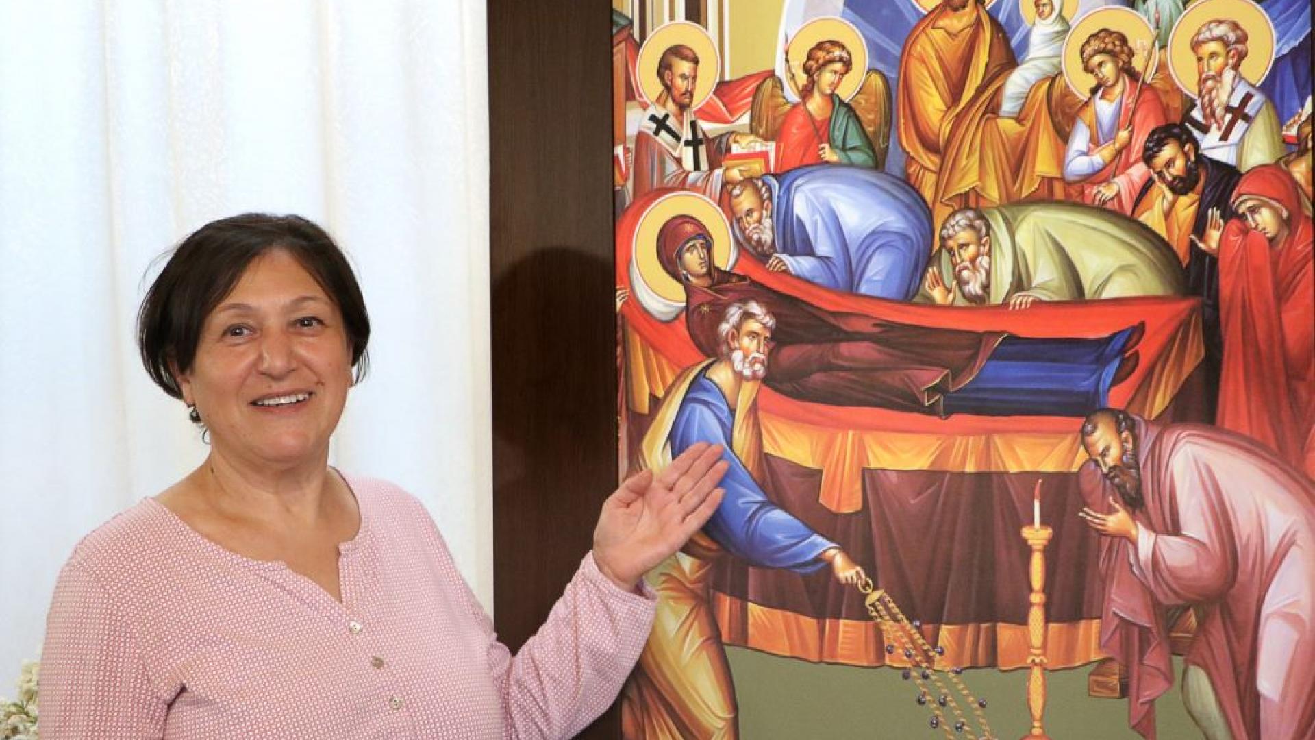 Frau vor einer Marienikone in einer orthodoxen Kirche