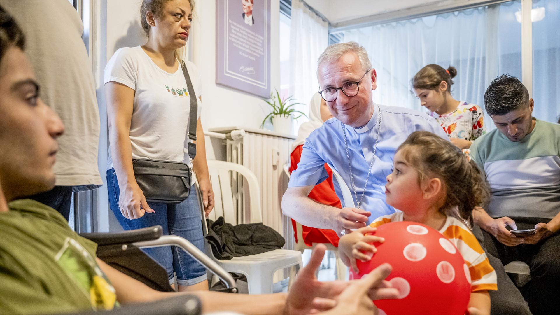 Izmir, Türkei: Erzbischof Stefan Heße spricht mit geflüchteten Familien in einem Kirchengemeinderaum.