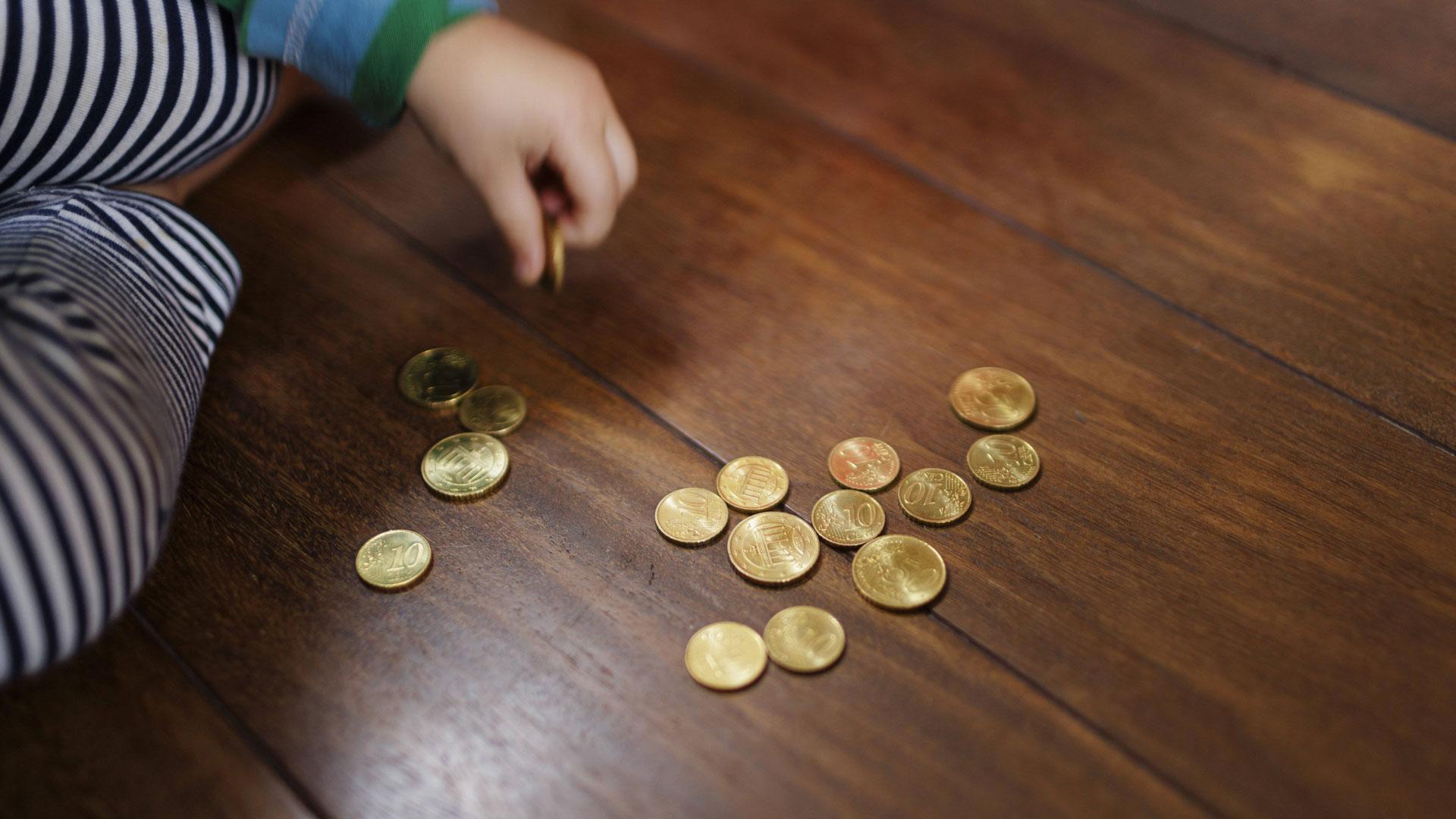 Kinderhand spielt mit Kleingeld