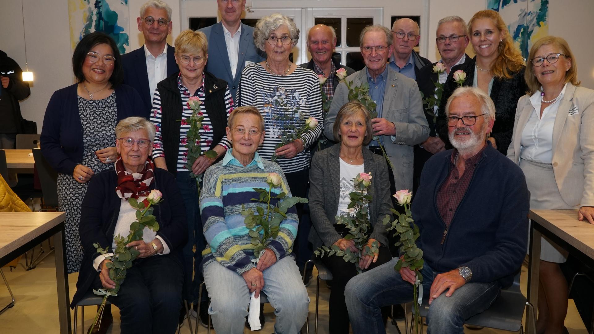 Mehrere Menschen haben sich zu einem Gruppenbild versammelt.