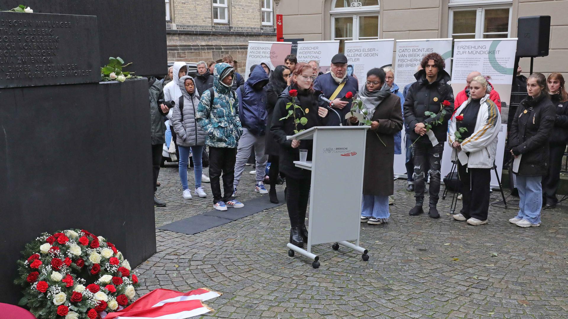 Eine Gruppe von jungen Menschen steht vor einem Haus