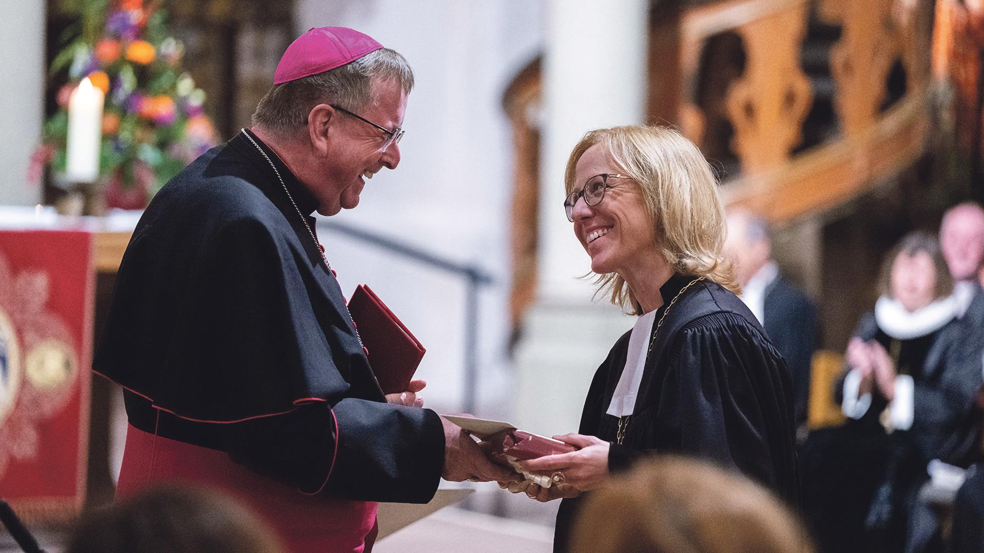 Bischöfin Nora Steen nimmt die Glückwünsche ihres katholischen Amtsbruders, Weihbischof Horst Eberlein, entgegen.