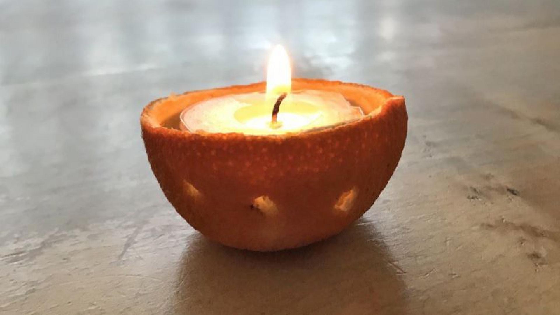 Ein Teelicht brennt in einer ausgehöhlten Orange