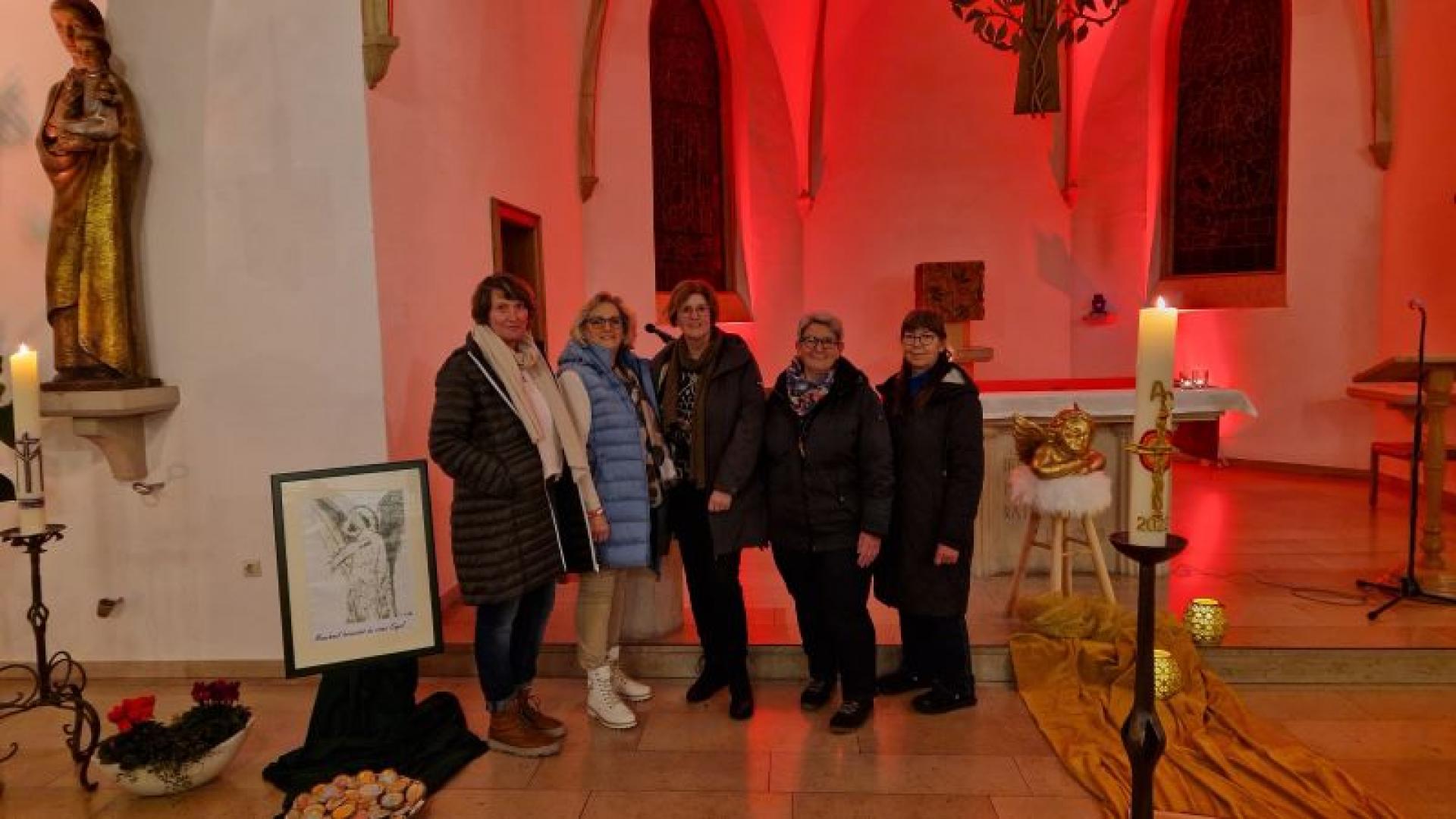 Eine Gruppe von Menschen steht im Altarraum der Kirche