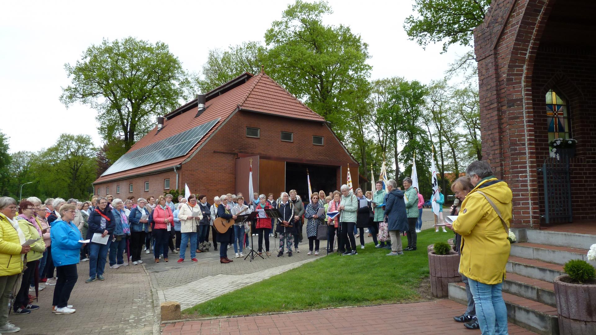 Viele Frauen stehen vor einer Grotte.