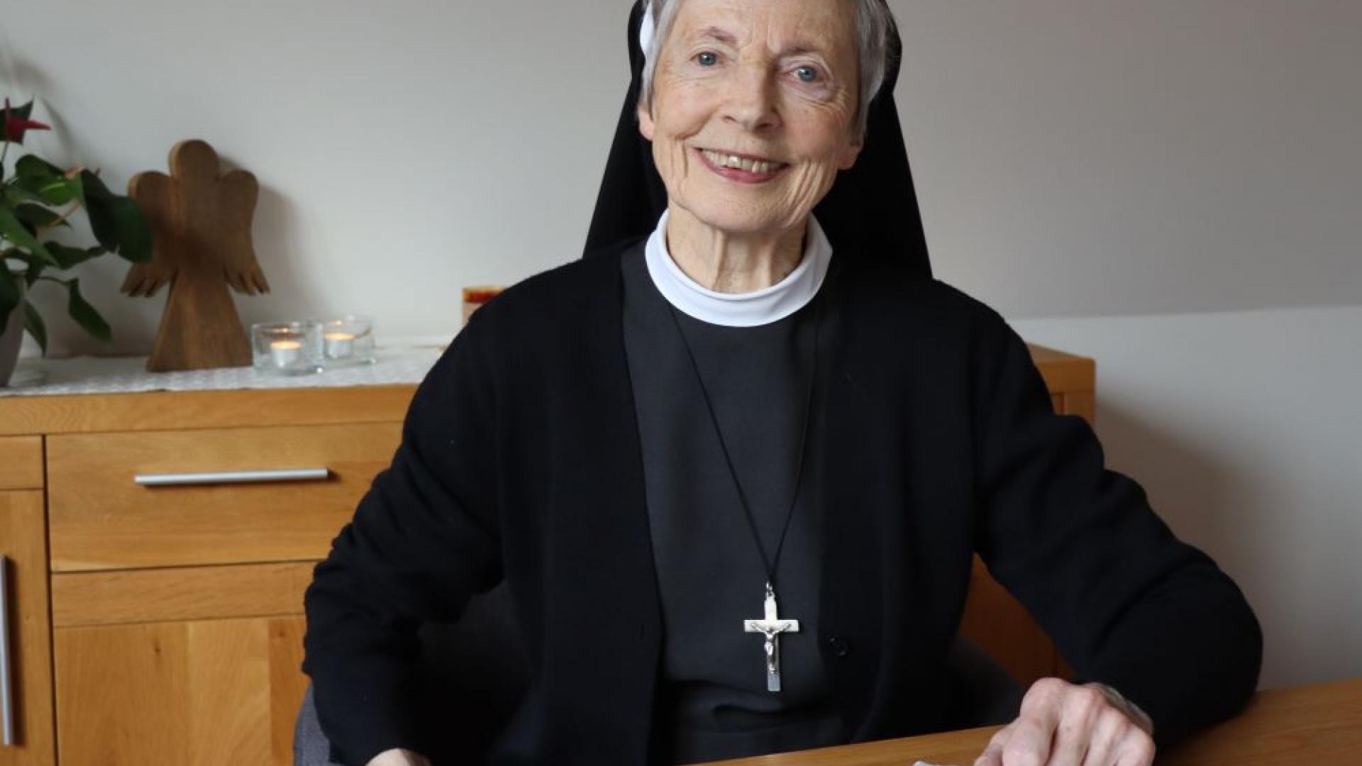 eine Ordensfrau am Tisch