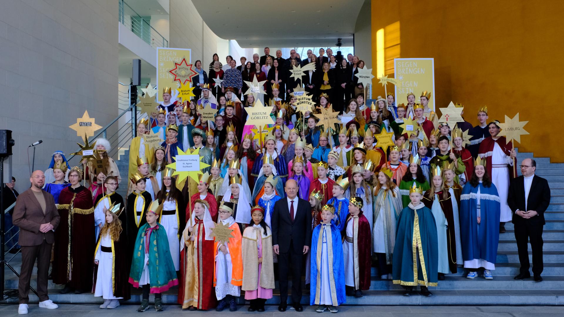 Kinder und Jugendliche im Sternsingerkostüm umringen Bundeskanzler Olaf Scholz
