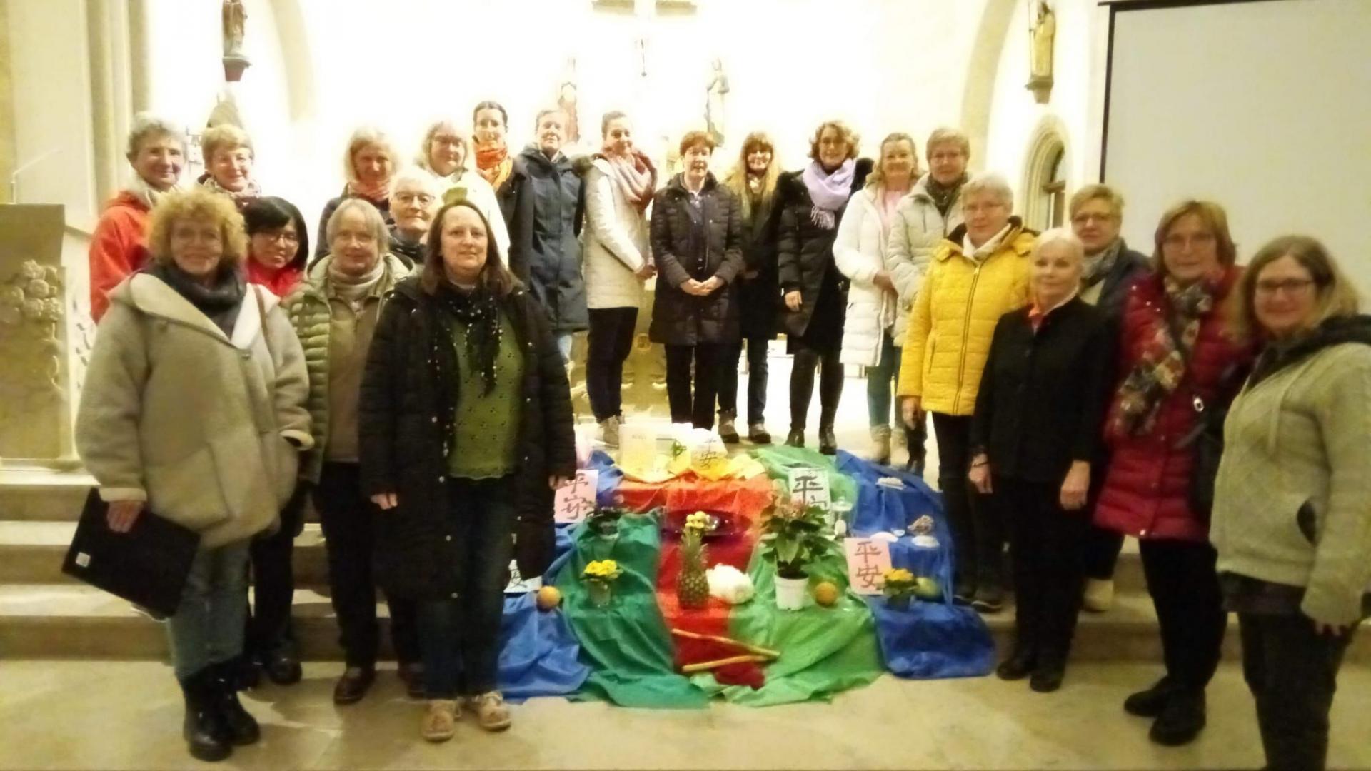 Eine Vielzahl von Frauen steht im Altarraum einer Kirche