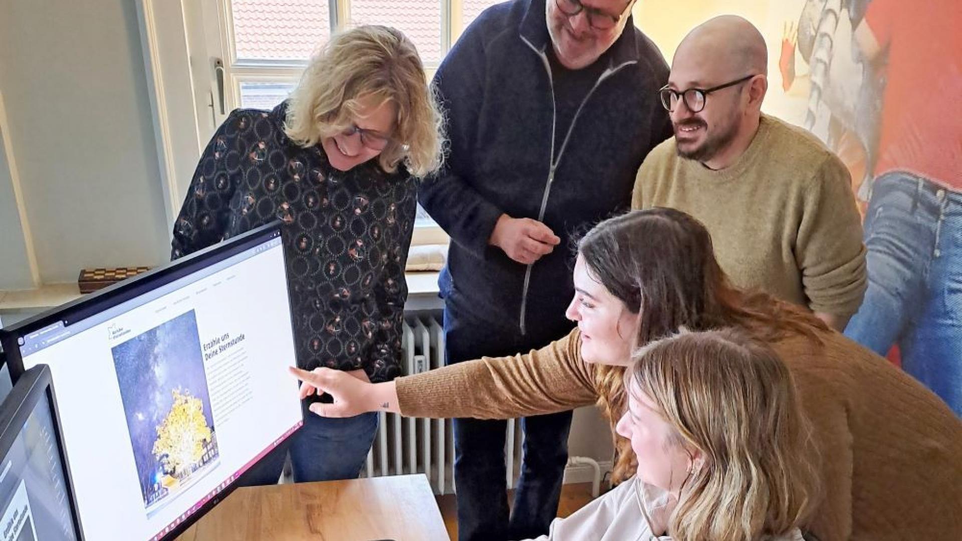 Mehrere Menschen vor einem Computer