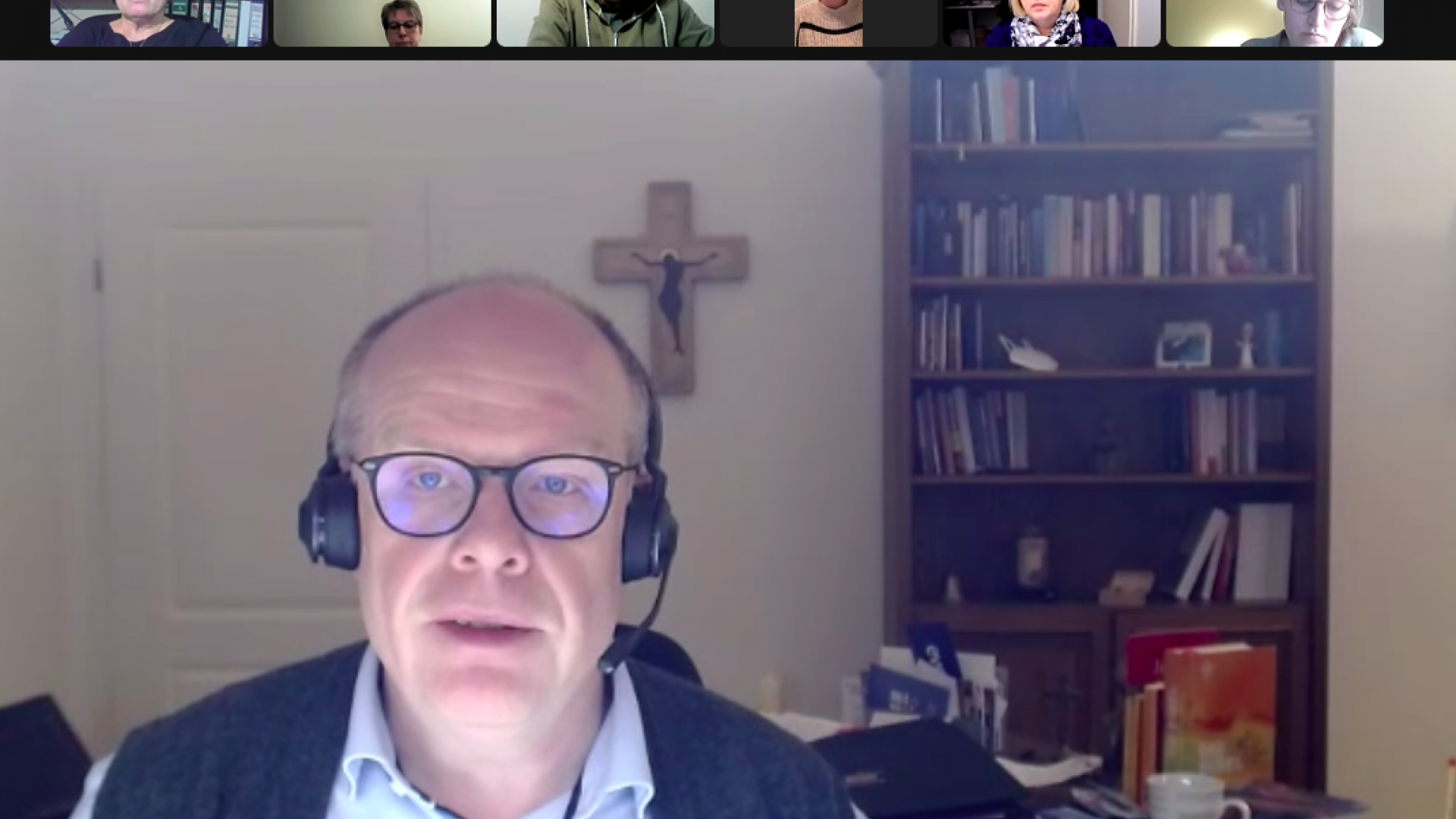 Ein Mann sitzt mit Kopfhörern an einem Schreibtisch