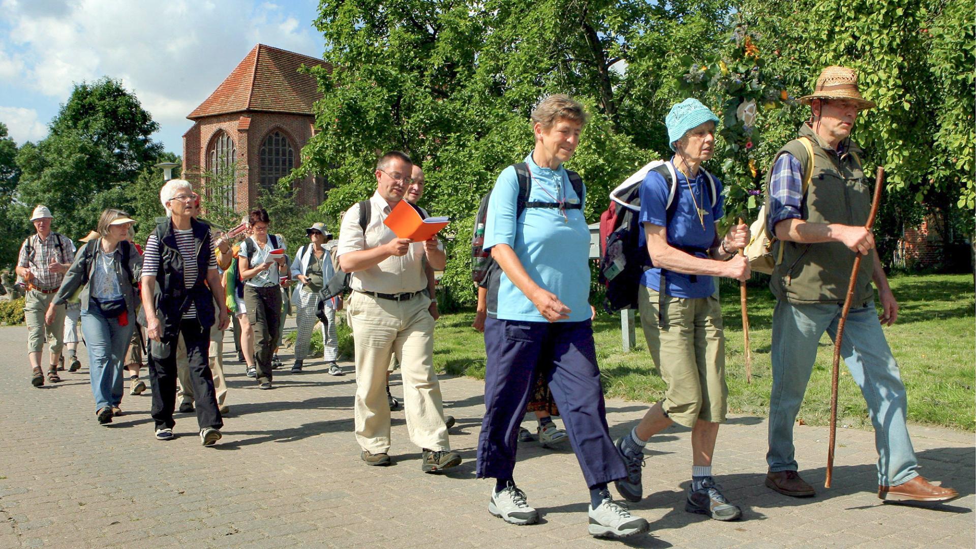 Pilger in Tempzin. Im Hintergrund die Klosterkirche