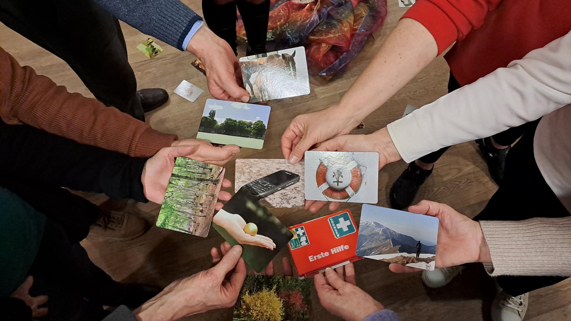 Viele Händen halten bunte Postkarten. 