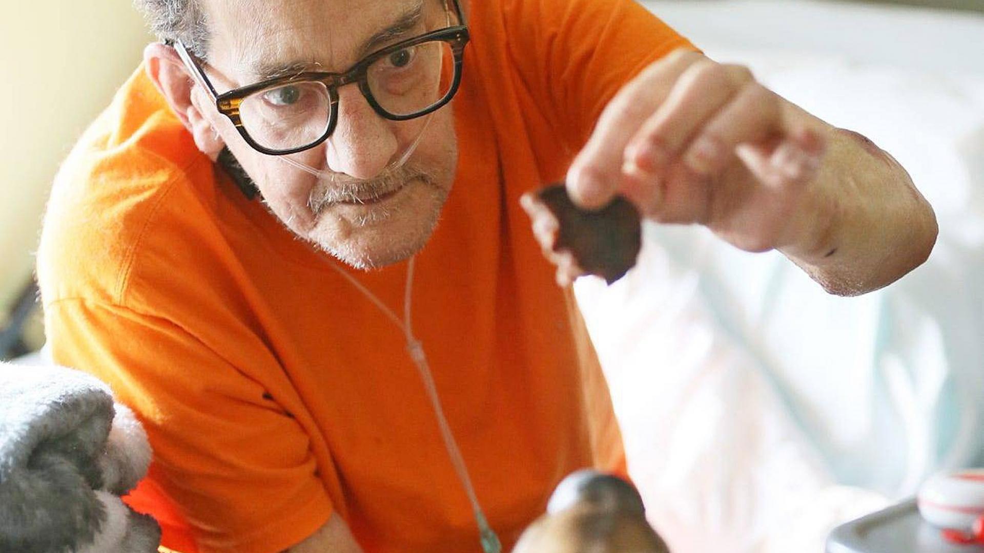 Mann im Hospiz füttert einen Hund