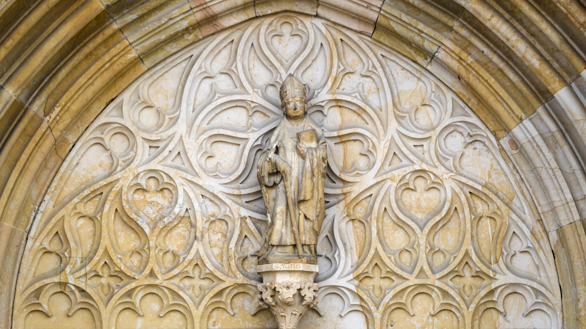 Eine Sandsteinfigur über einem Hauptportal