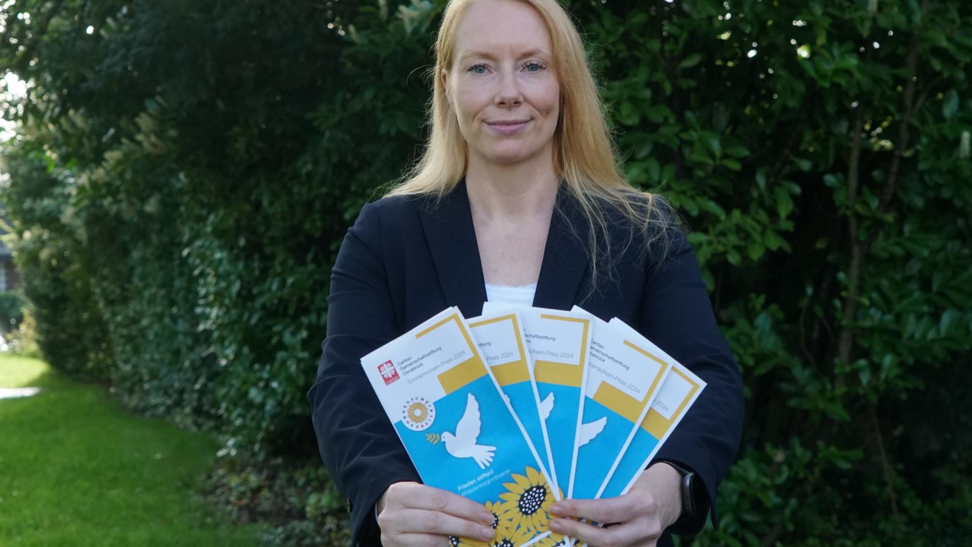 Eine Frau hält mehrere Flyer in den Händen