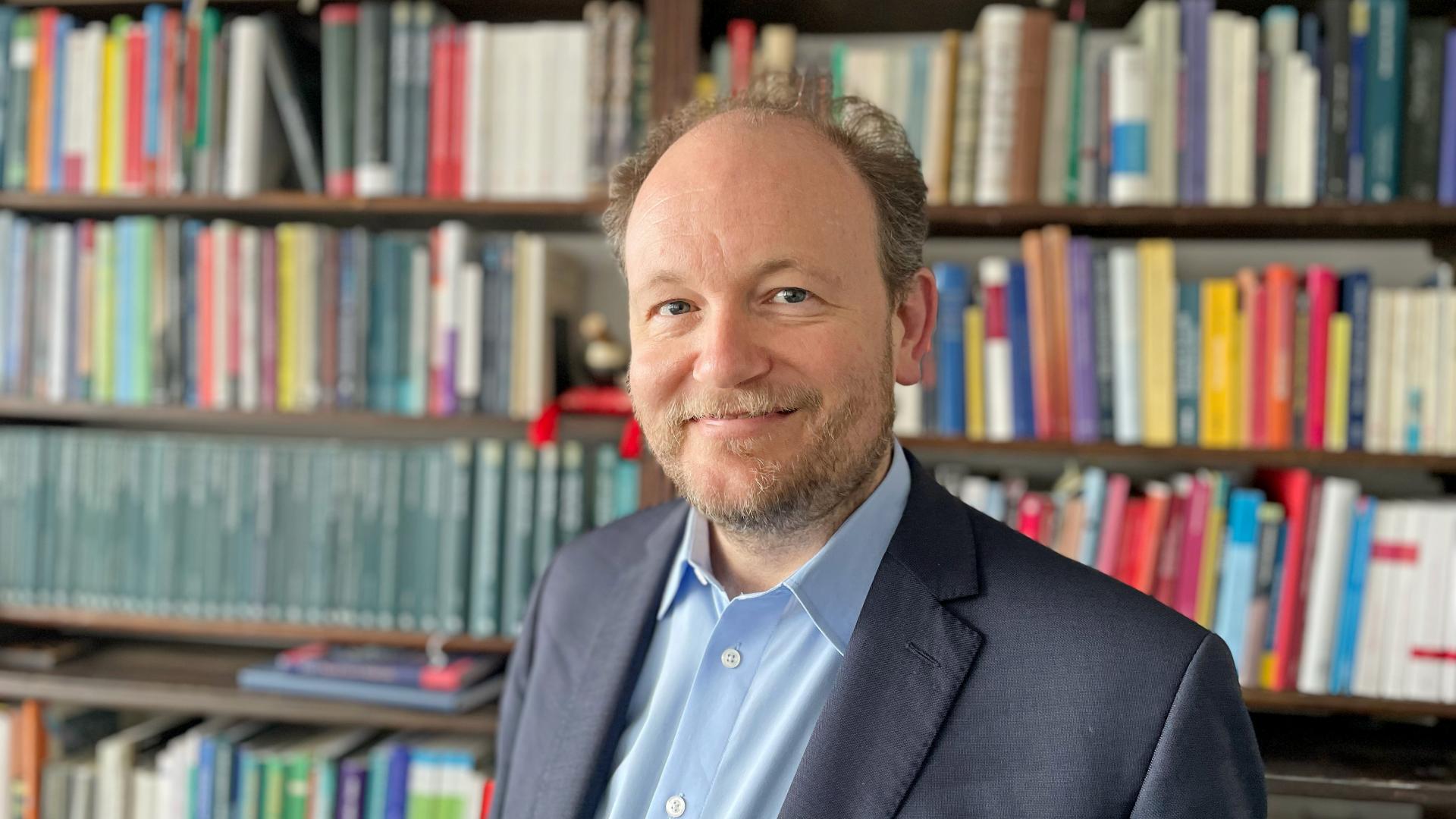 Mann vor Bücherregal